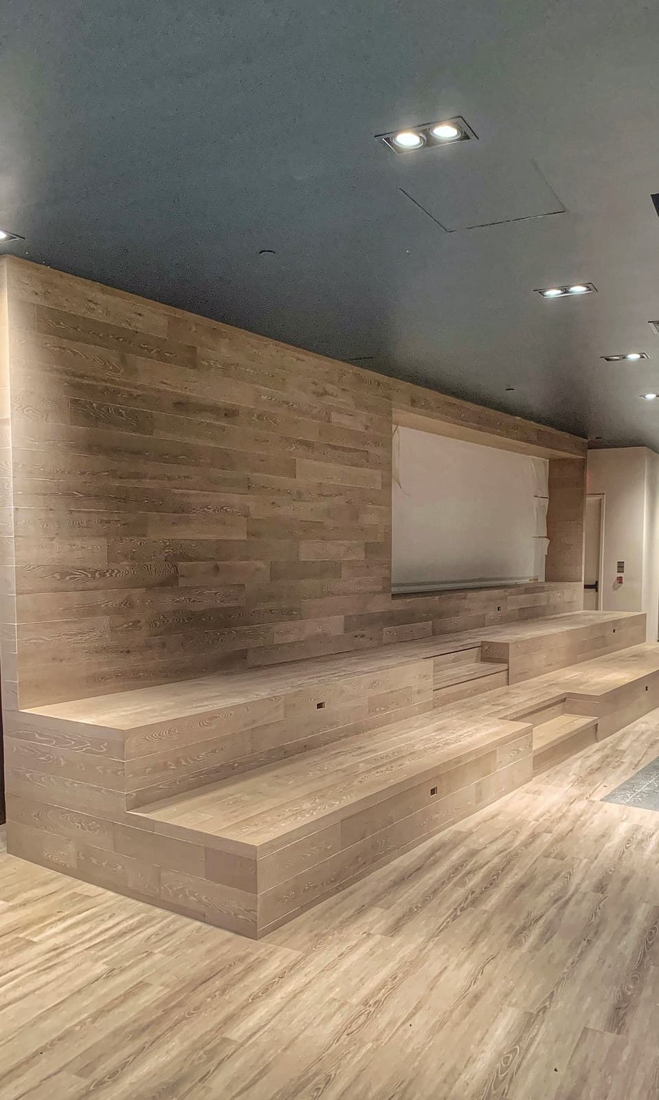 Minimal light hardwood flooring running down a bright hallway