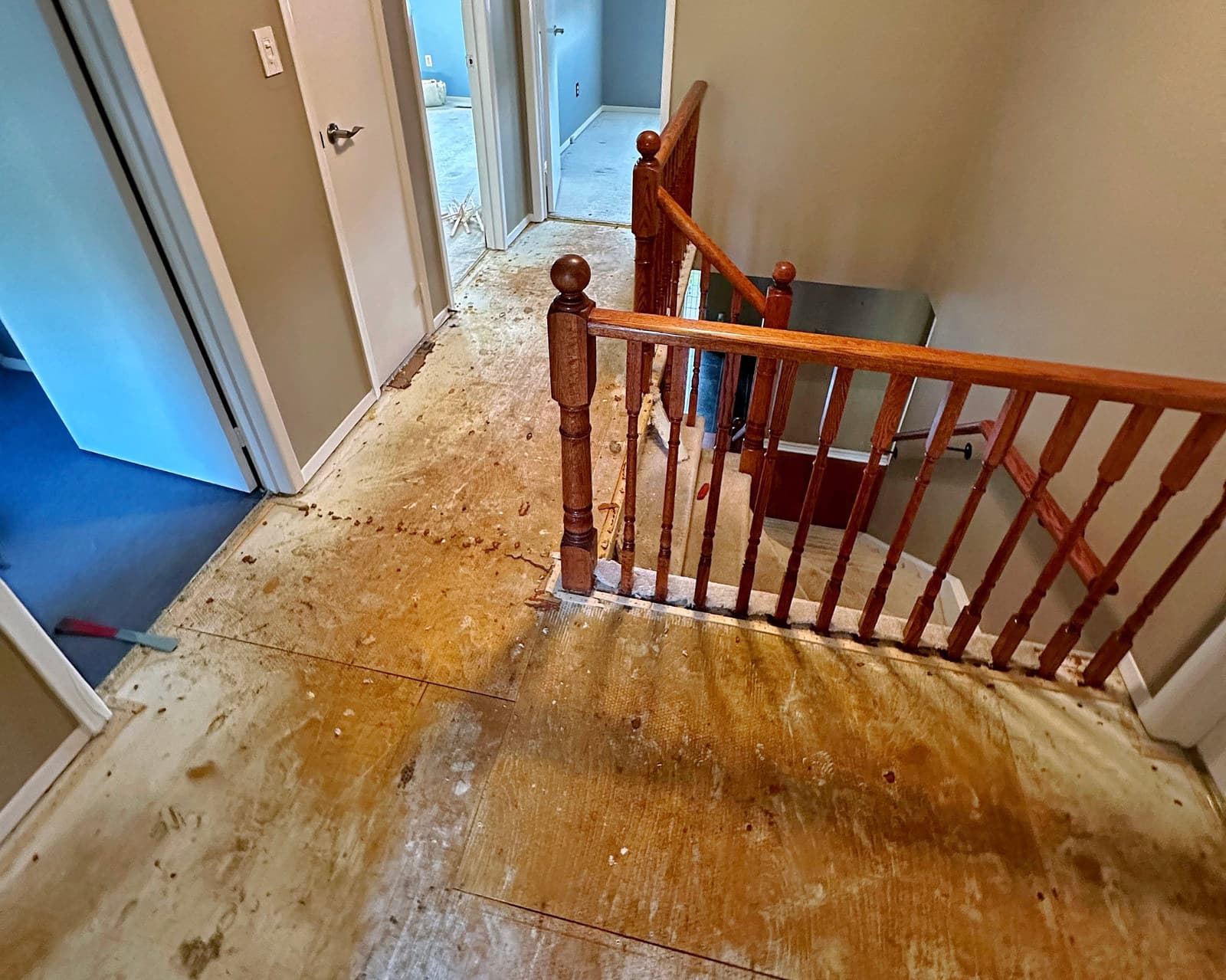 A worn upper-floor landing and staircase before new flooring was installed