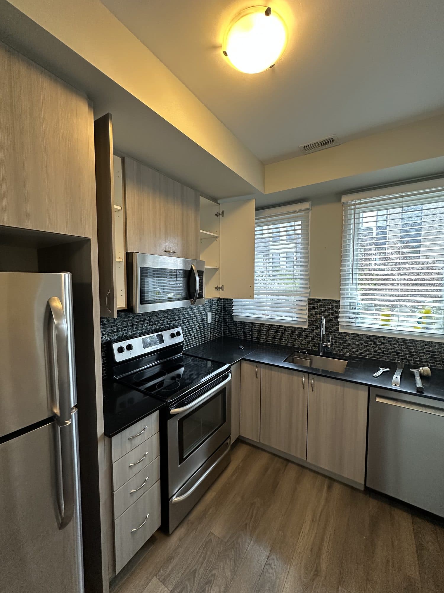 An older kitchen with dark granite and stained cabinets before renovation