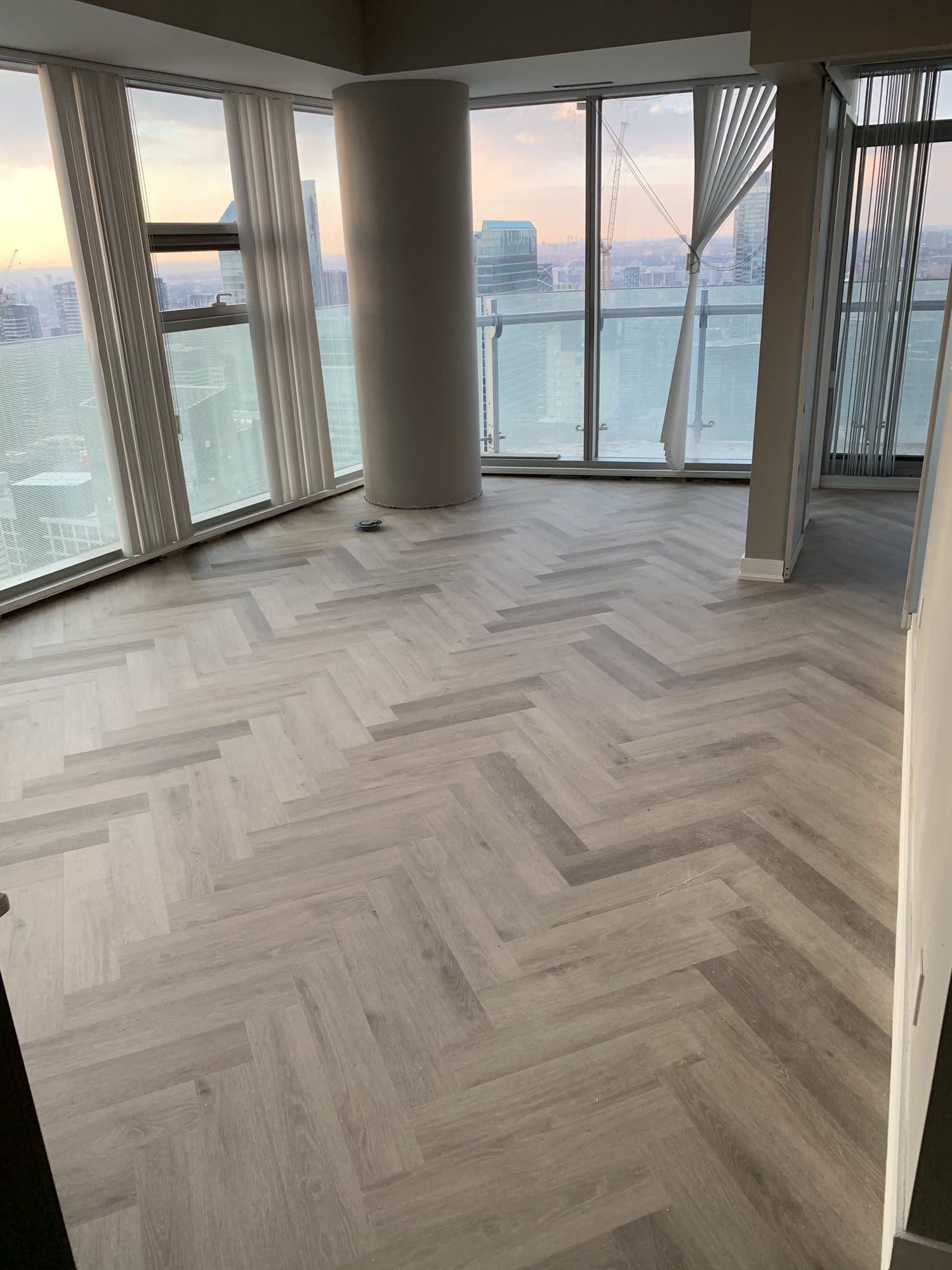 The same corner condo finished with a light herringbone floor