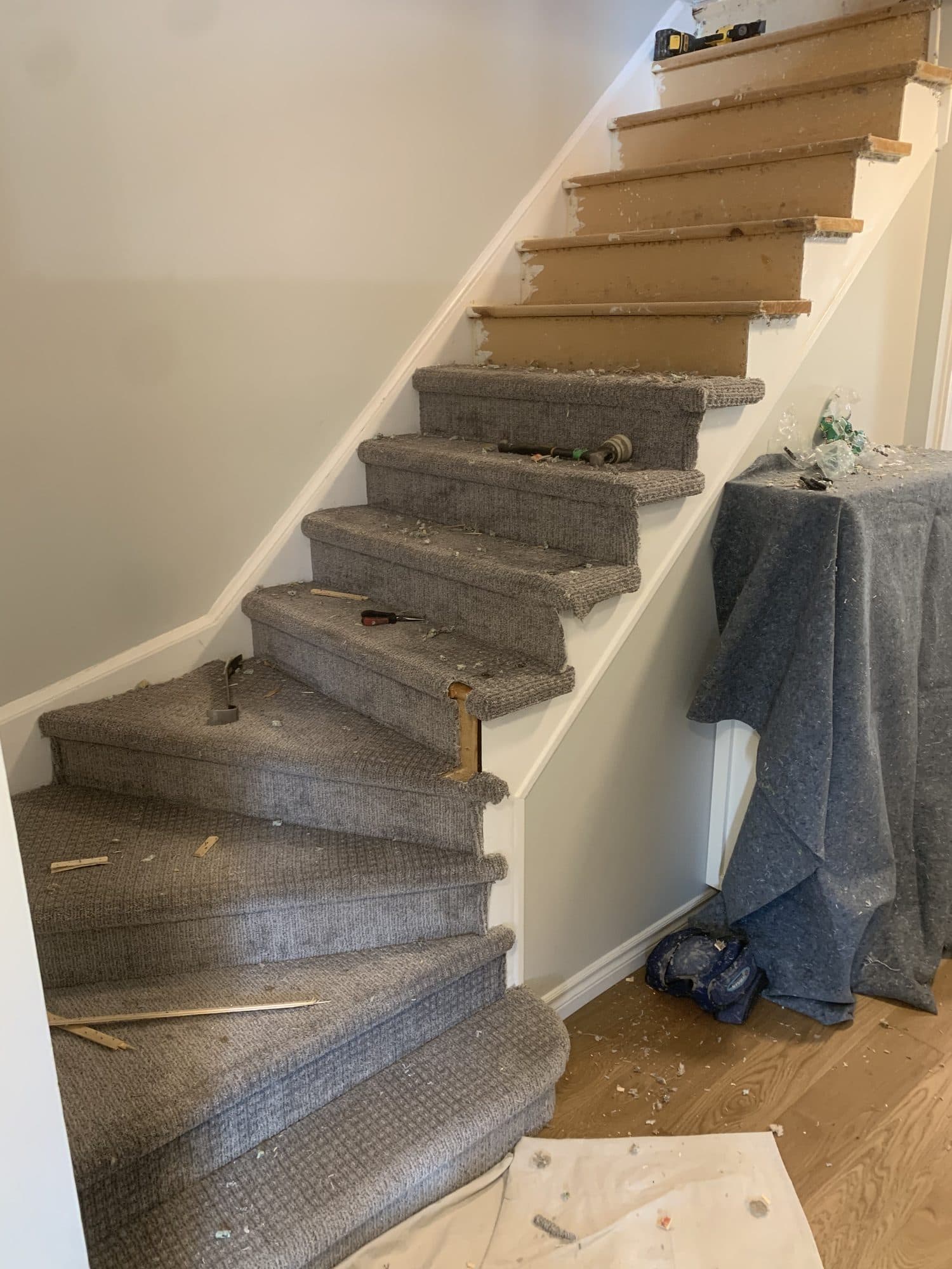 A tired, grey-carpeted staircase before renovation