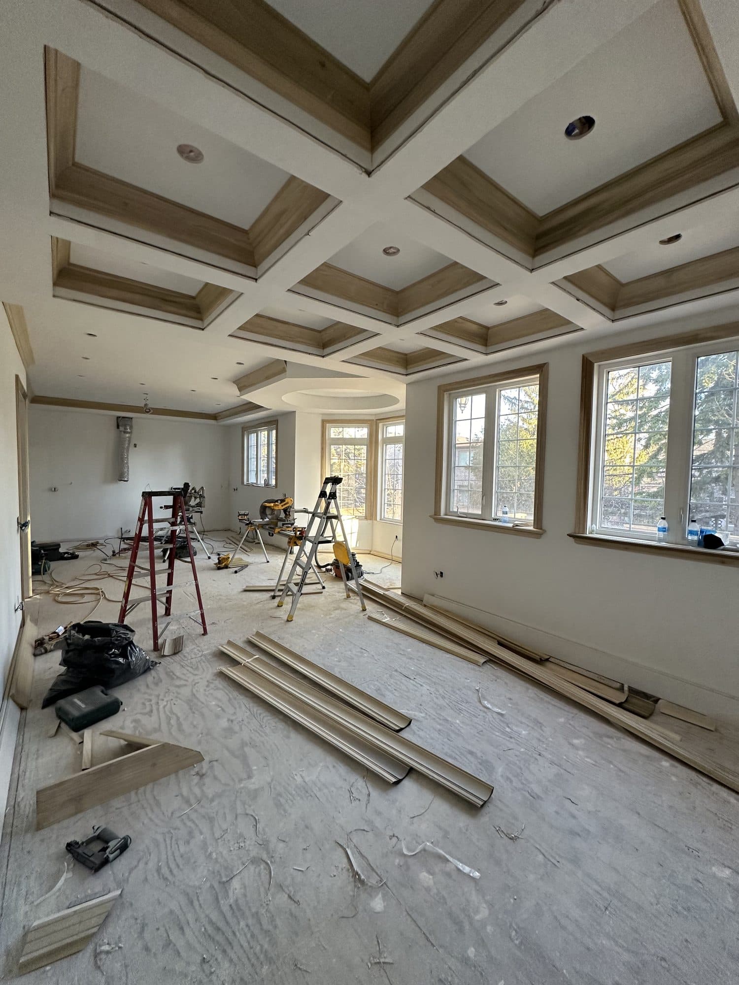 A coffered ceiling being trimmed in wood during the build