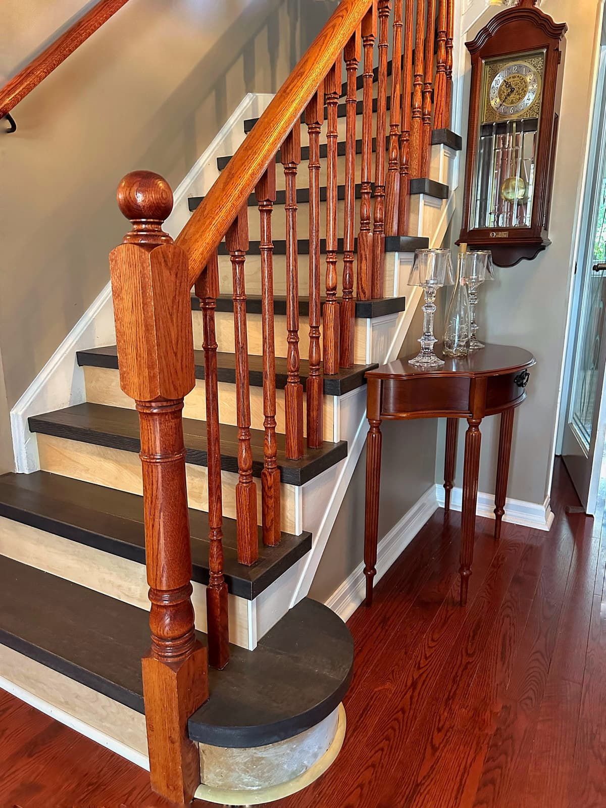 A classic oak staircase with dark treads, white risers and a turned railing