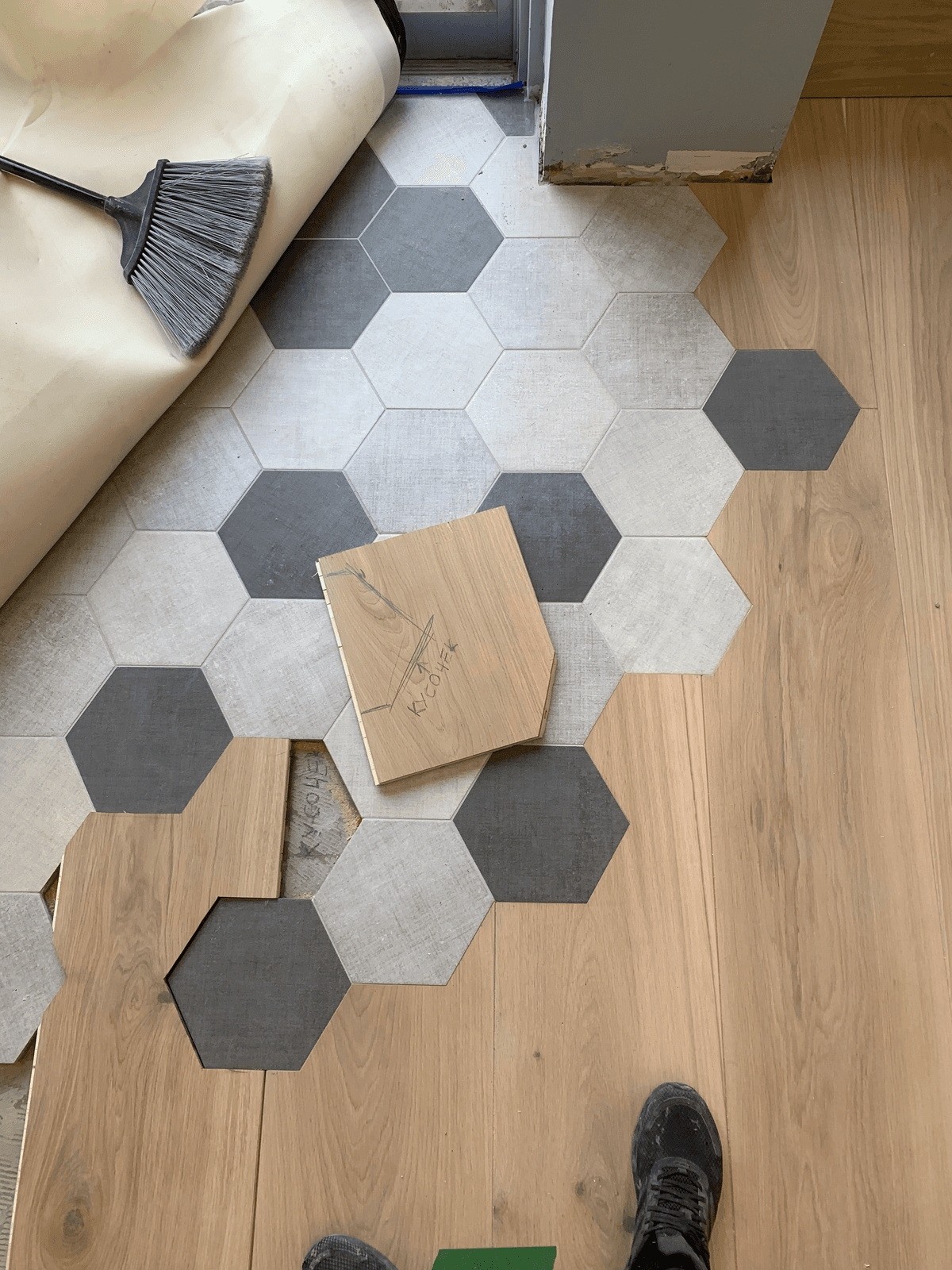 A clean transition between herringbone hardwood and patterned encaustic tile