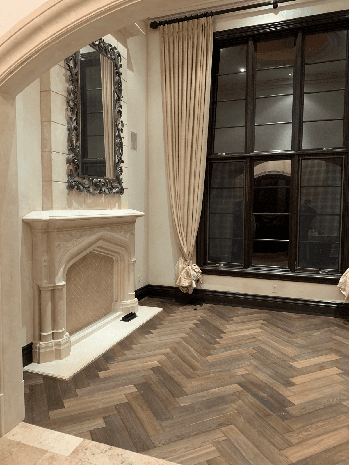 Herringbone hardwood flooring in an elegant living room with a fireplace