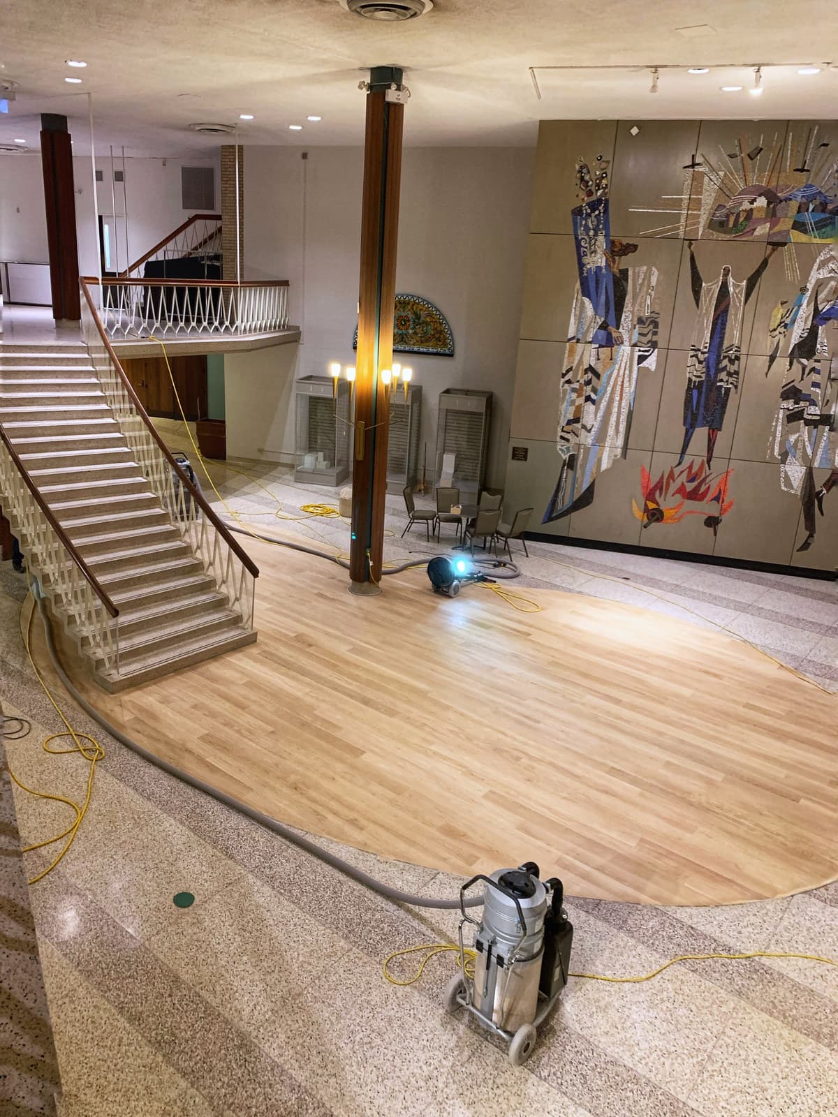 An open interior mid-renovation with a staircase and new hardwood flooring