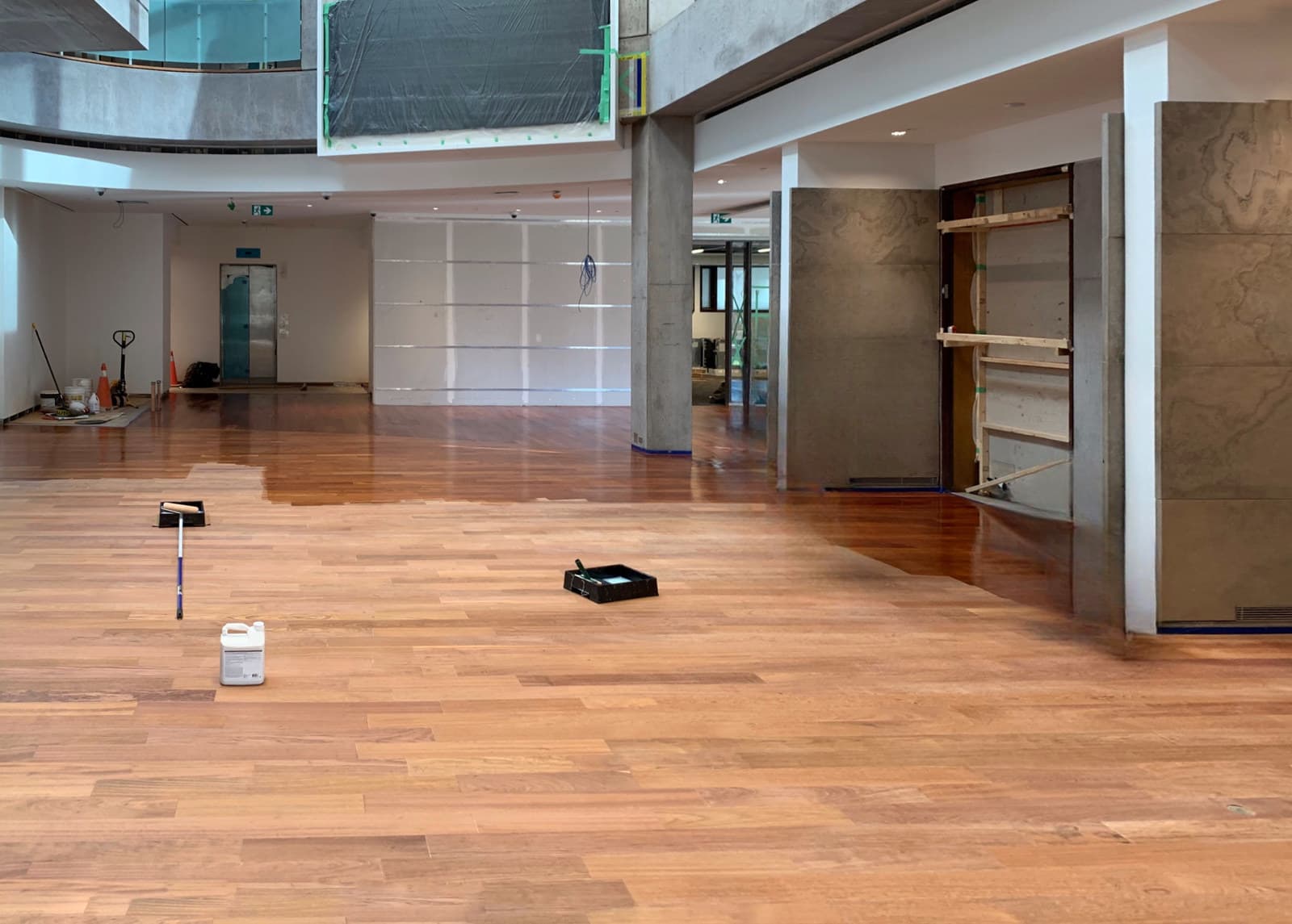 A freshly refinished hardwood floor across a large open interior